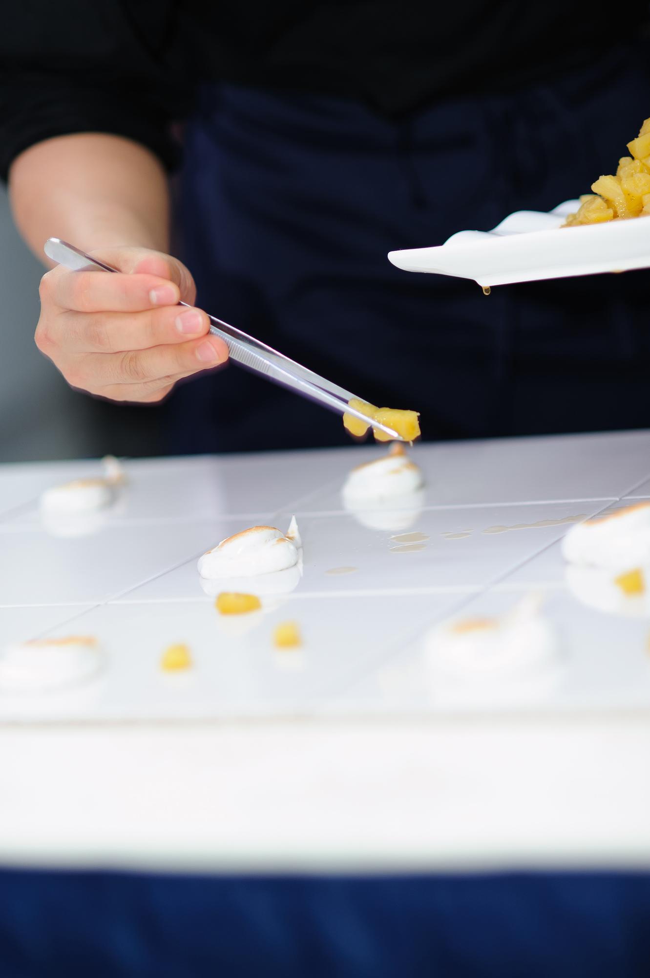 Instructor arranging tasting plates in a studio kitchen